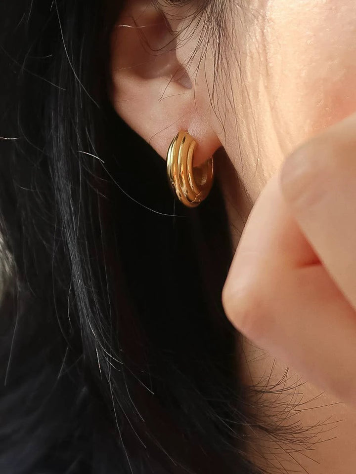 18K gold triple-band chunky hoop earring on a model&