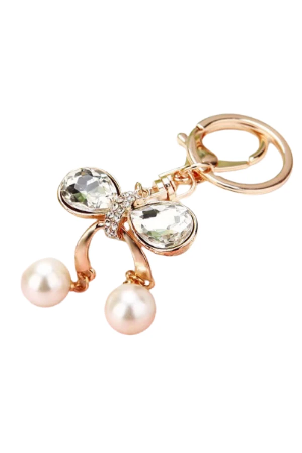 Rose-gold crystal bow charm with faceted crystal wings and two pearl drops on a circular key ring.