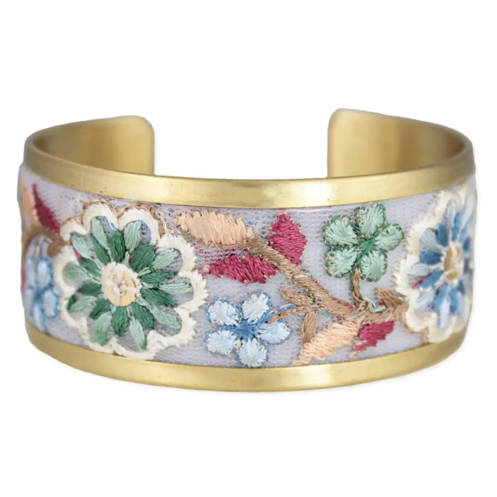 Pastel embroidered floral cuff bracelet with lavender fabric, gold-tone metal edges, and colorful stitched blossoms.