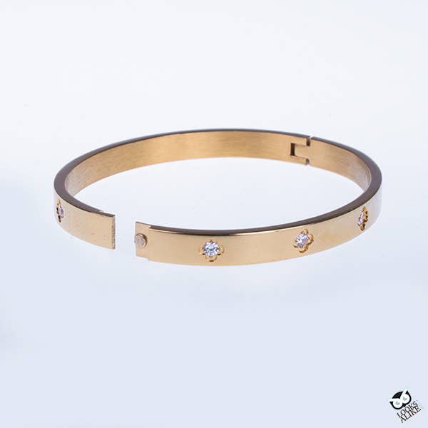 Gold plated bangle with flower-shaped settings and small clear stones along the band, open-ended.