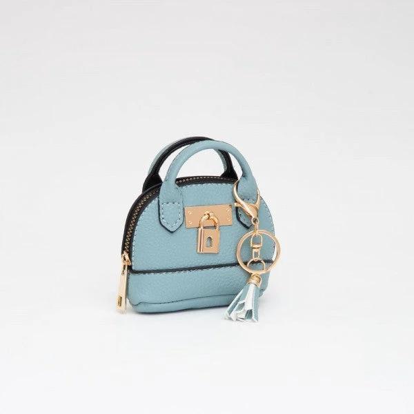 Light blue mini vegan leather purse with zip closure, twin top handles, gold lock charm, and tassel keyring.