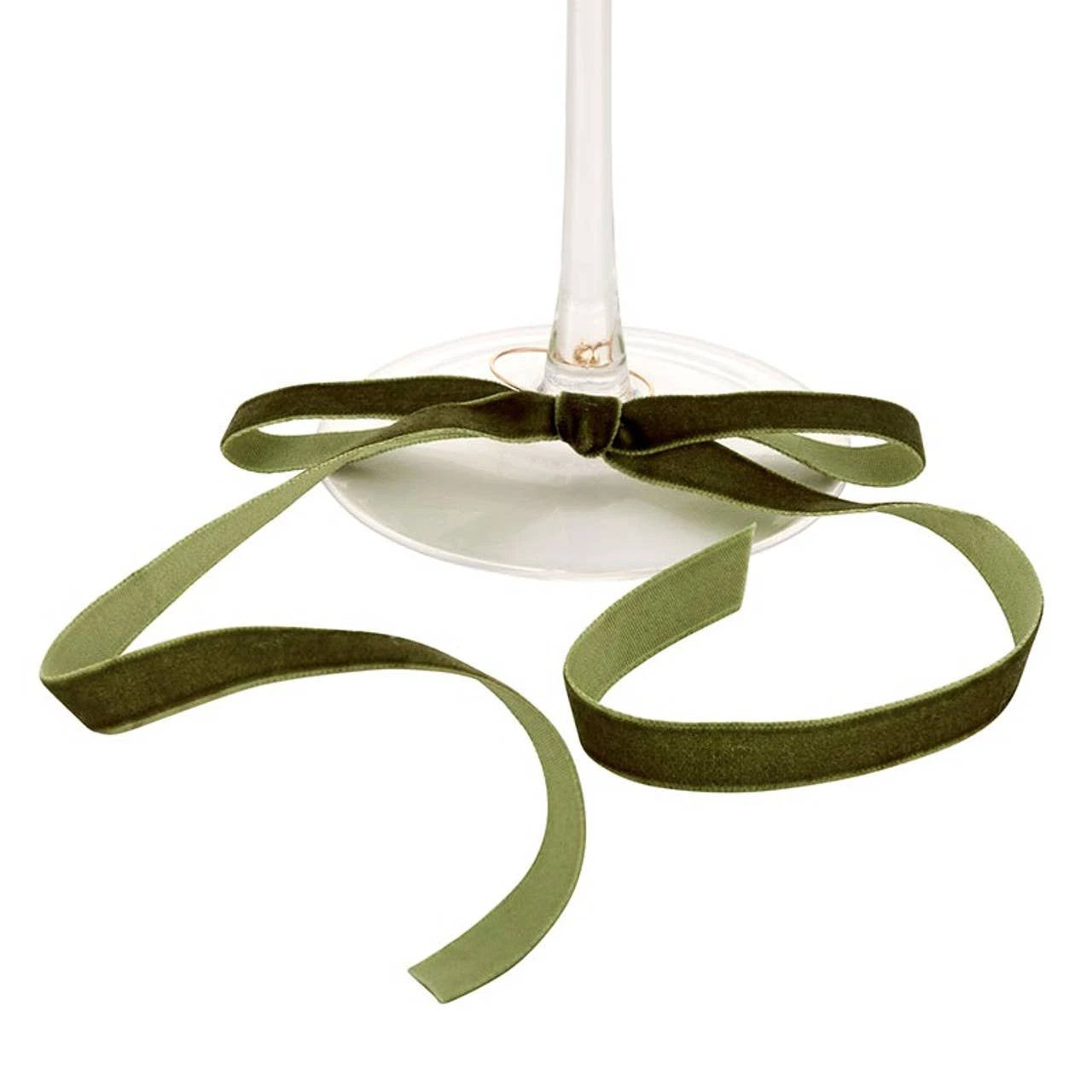 Green velvet bow tied around a wine glass stem, with long ribbon tails.