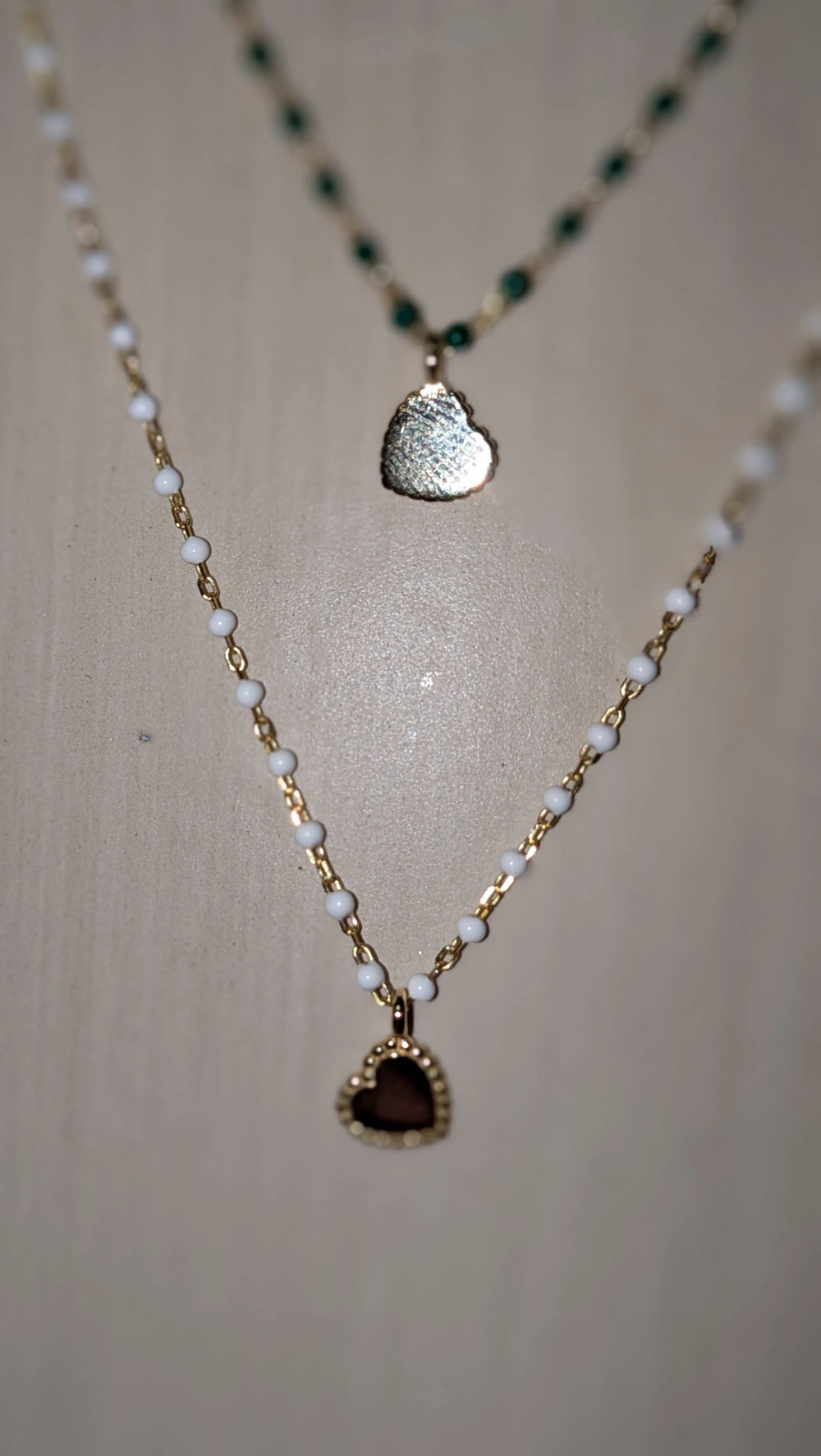 Elsa Mini Heart Necklace Green, layered gold-tone chain with white beads and burgundy heart pendant.