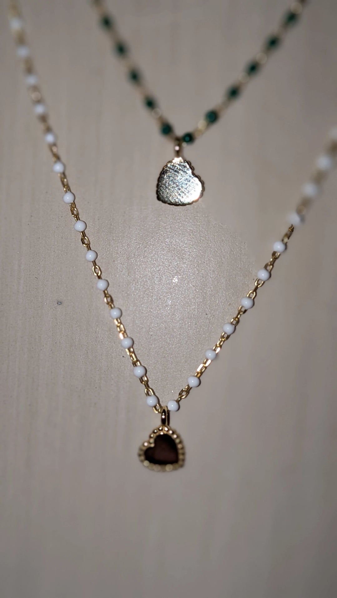 Elsa Mini Heart Necklace Green, layered gold-tone chain with white beads and burgundy heart pendant.