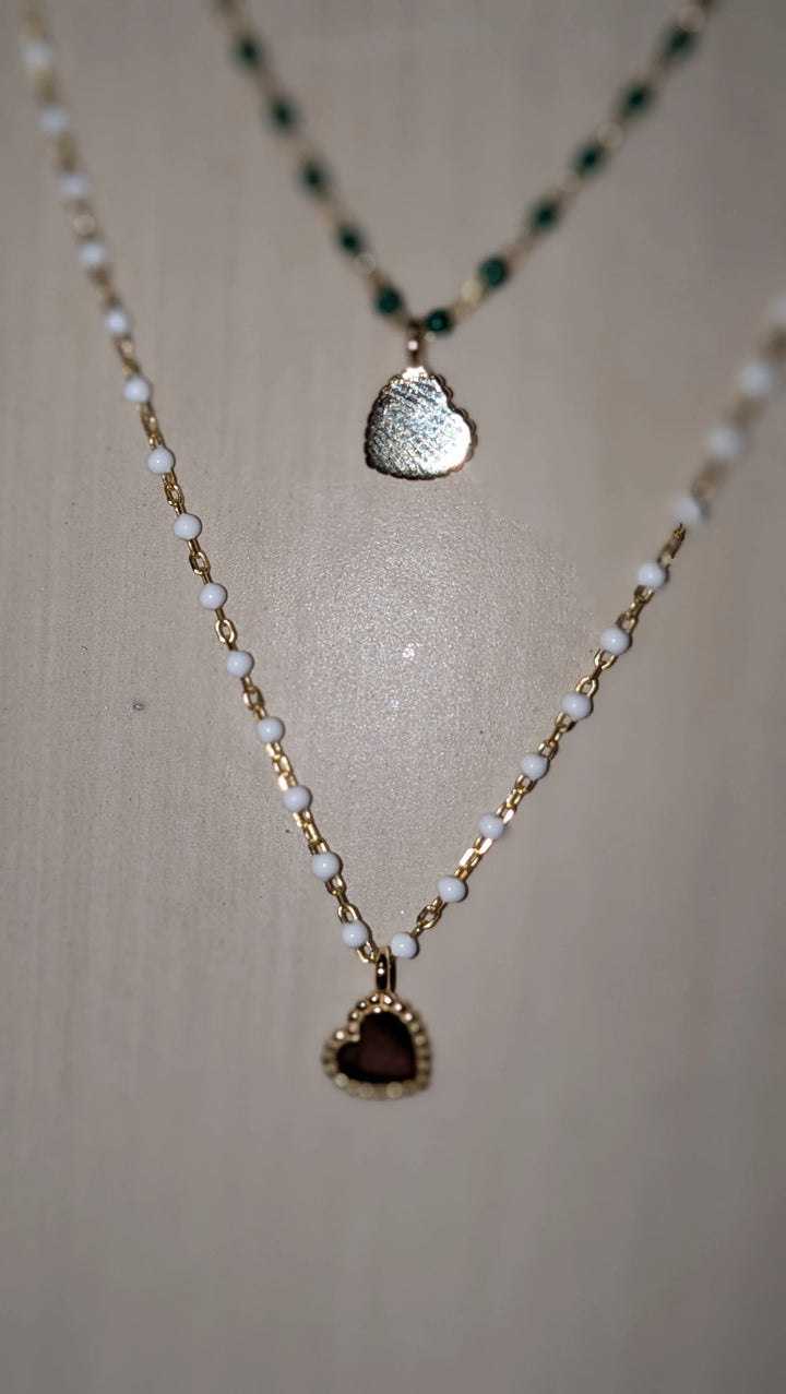 Elsa Mini Heart Necklace Green, layered gold-tone chain with white beads and burgundy heart pendant.