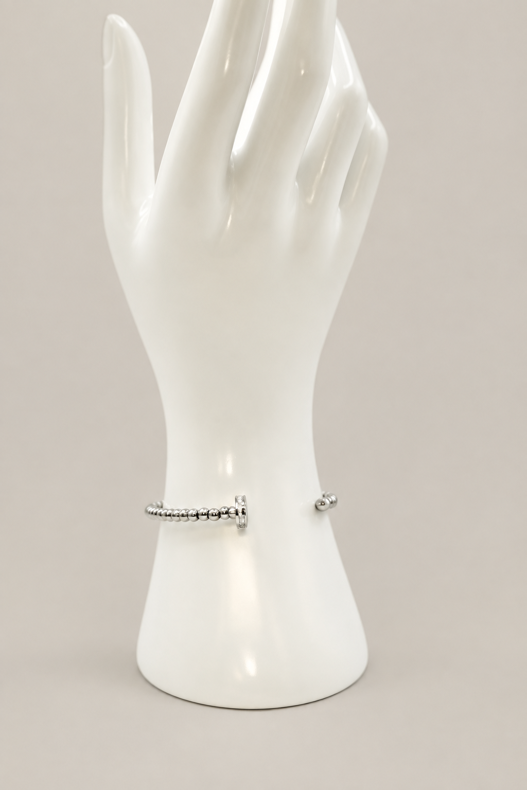 Beaded Nail Bracelet in silver with a matching warm-gray background