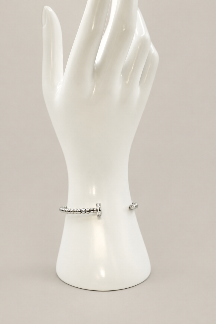 Beaded Nail Bracelet in silver with a matching warm-gray background