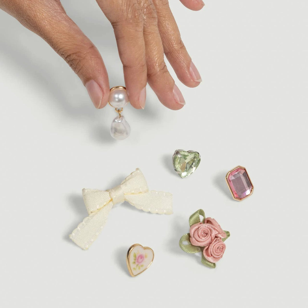 KitschPop 6pc charm set in vintage pink by KITSCH; includes bow, roses, heart, pearls, and pink/green gems.