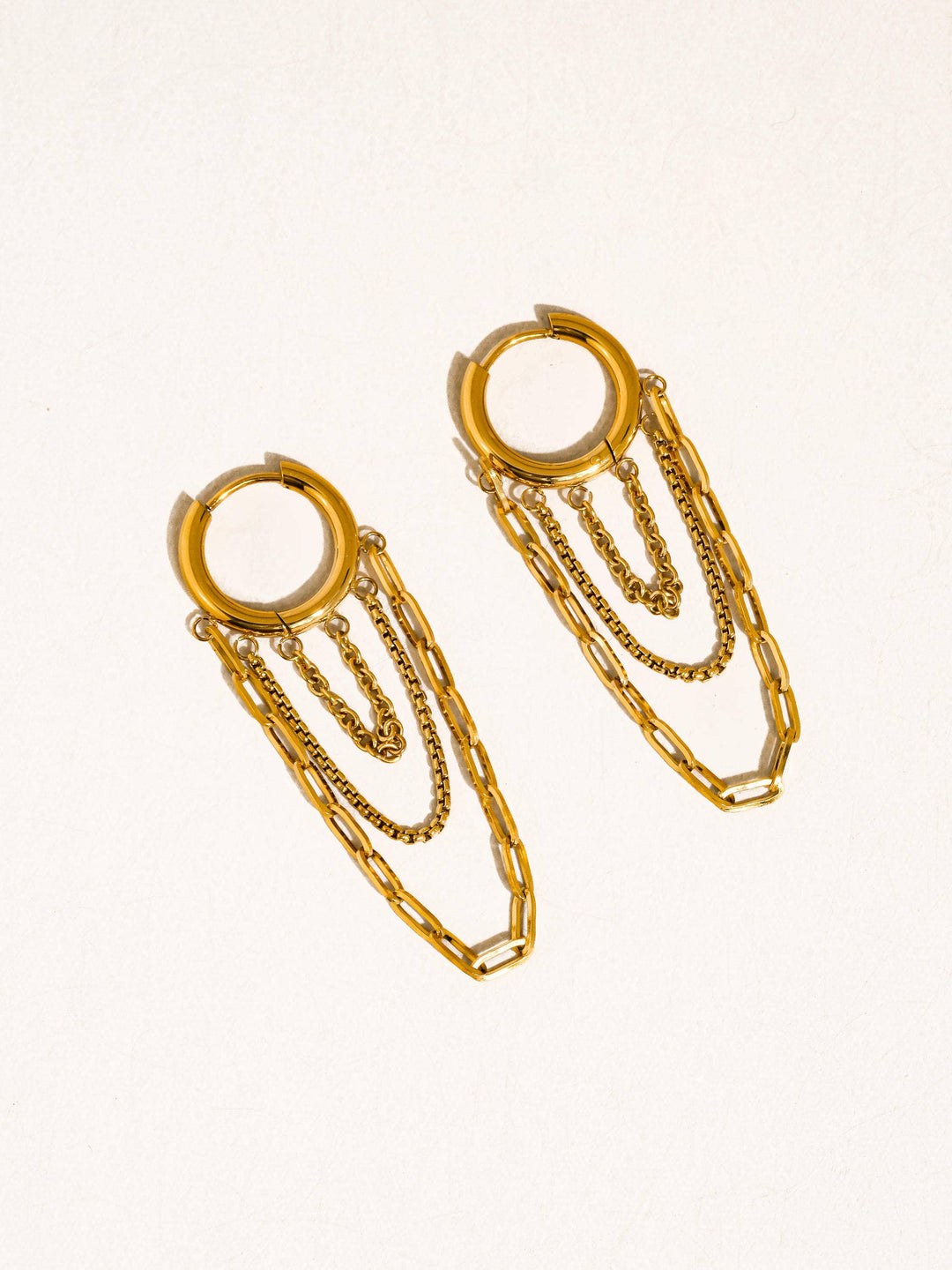 Gold-tone hoops with three dangling chains in mixed link styles for a bold multi-chain drop.