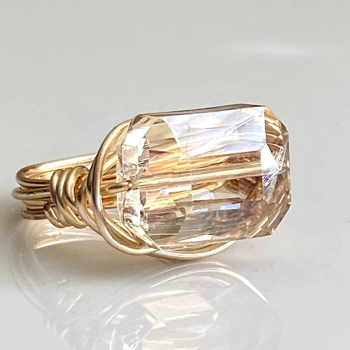 Gold-tone ring with a large rectangular champagne crystal, wrapped in looping twisted wire.