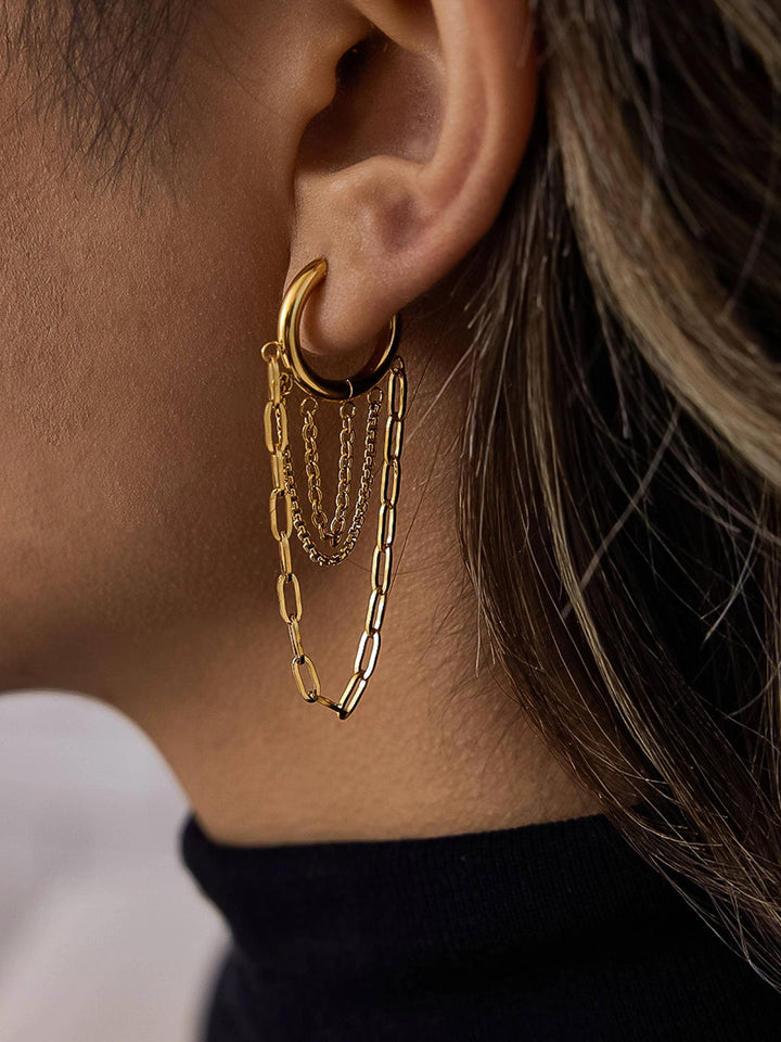 Gold-tone hoop with three cascading chain strands of varying widths, worn on a model&