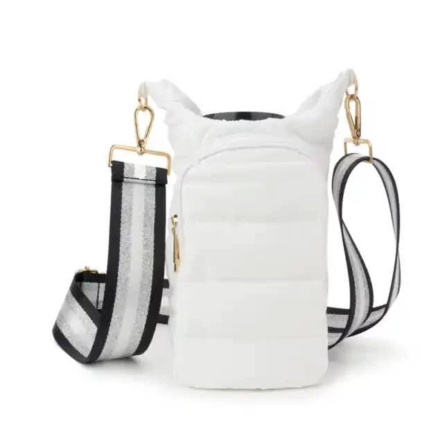 White padded tumbler carrier bag with gold hardware and straps: a wide striped crossbody strap and a slim black strap.