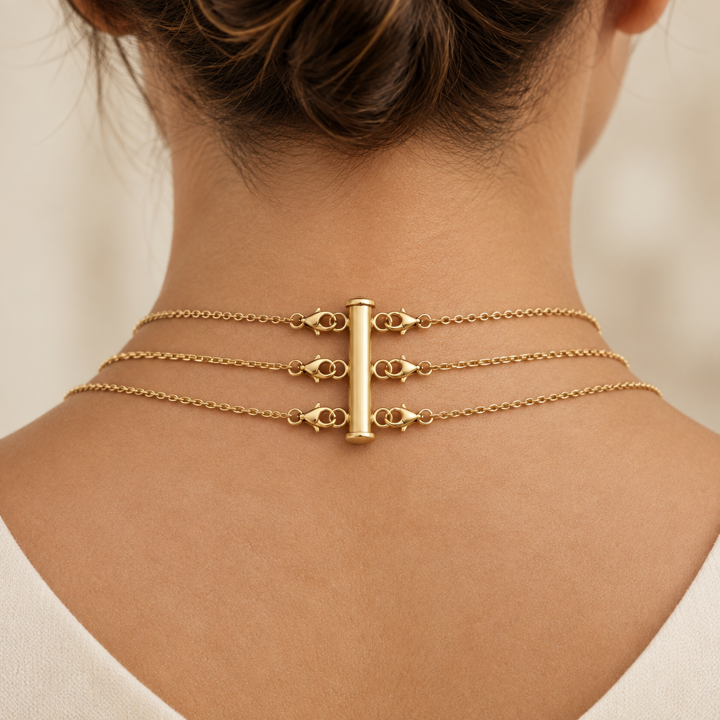 Gold layering clasp worn with three necklaces attached