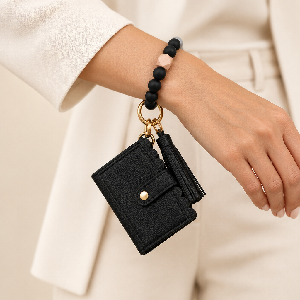 Black beaded bracelet keyring wallet with tassel worn on a woman's wrist