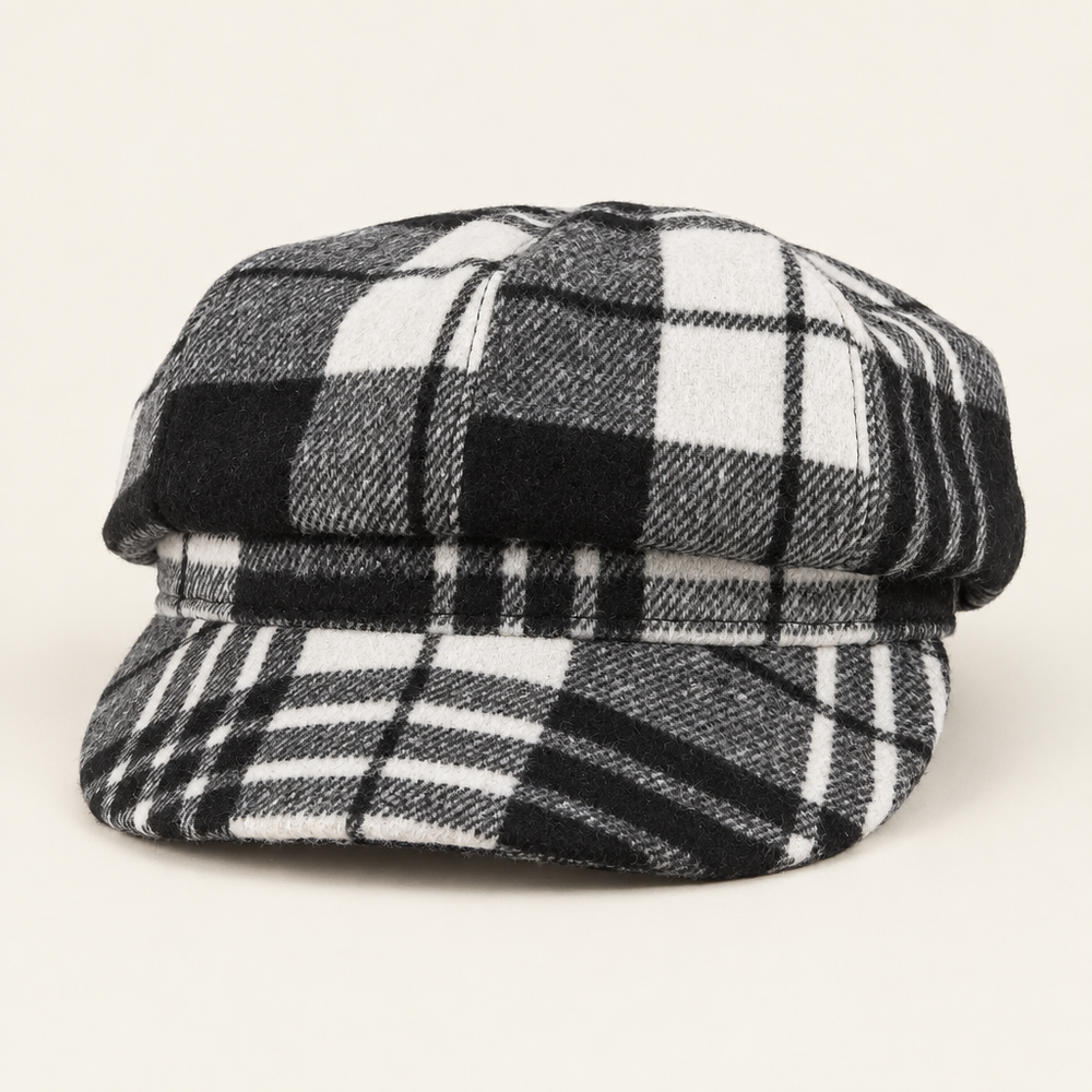 Black, gray and white tartan plaid newsboy cap on an off-white background