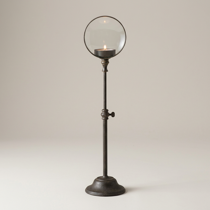 Iron candle holder on a clean warm-gray background