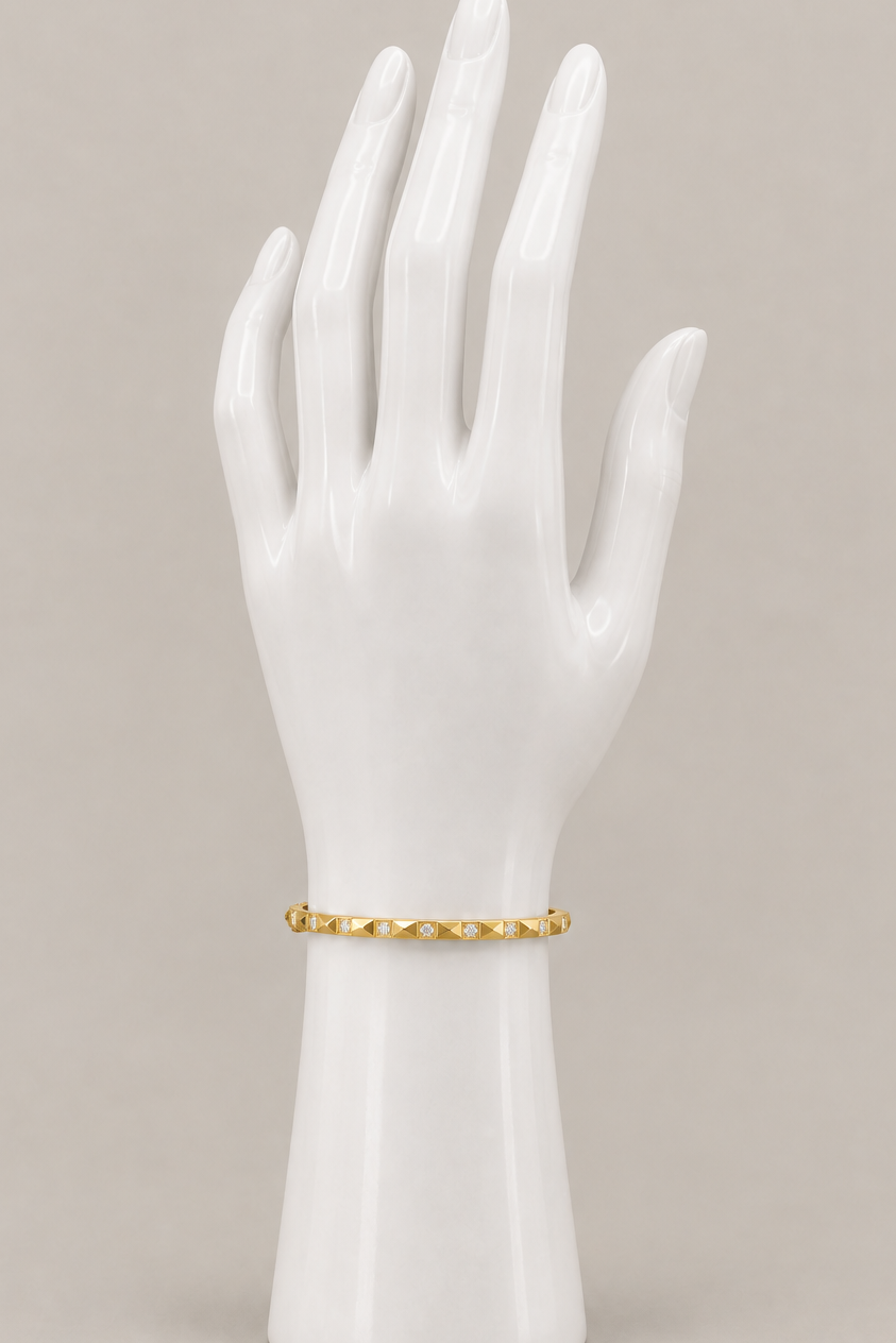 Jamie Bracelet in gold on an upright display