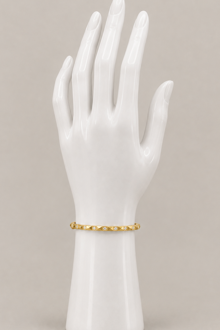 Jamie Bracelet in gold on an upright display