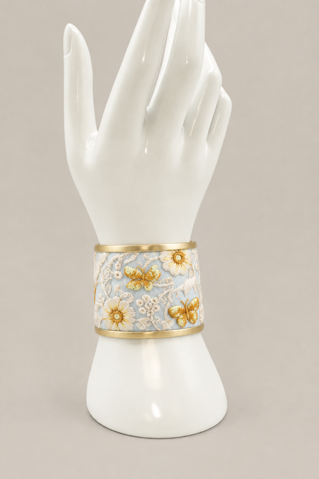 Medium-width ivory floral cuff on a white display hand