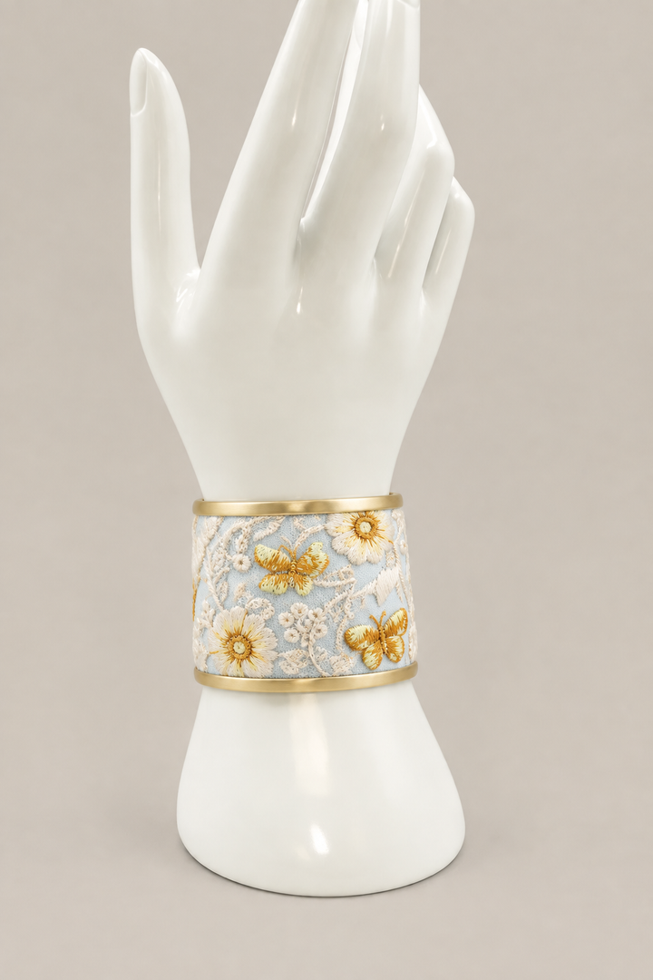 Medium-width ivory floral cuff on a white display hand