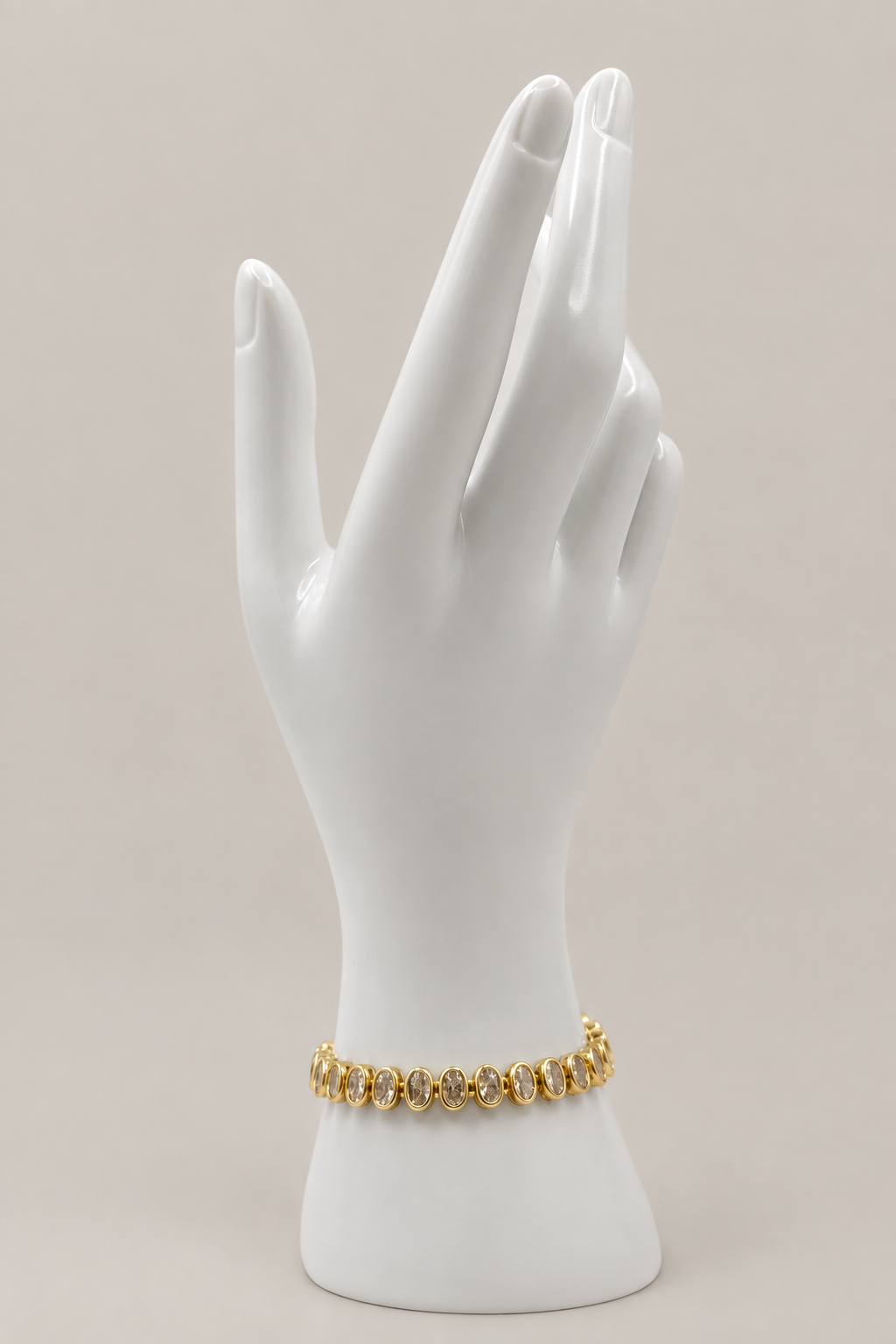 Oval Bezel Tennis Bracelet with a matching warm-gray background