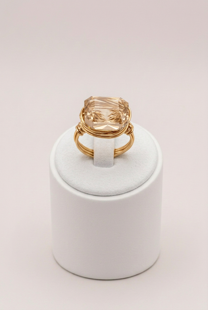 Straightened champagne crystal ring on white stand