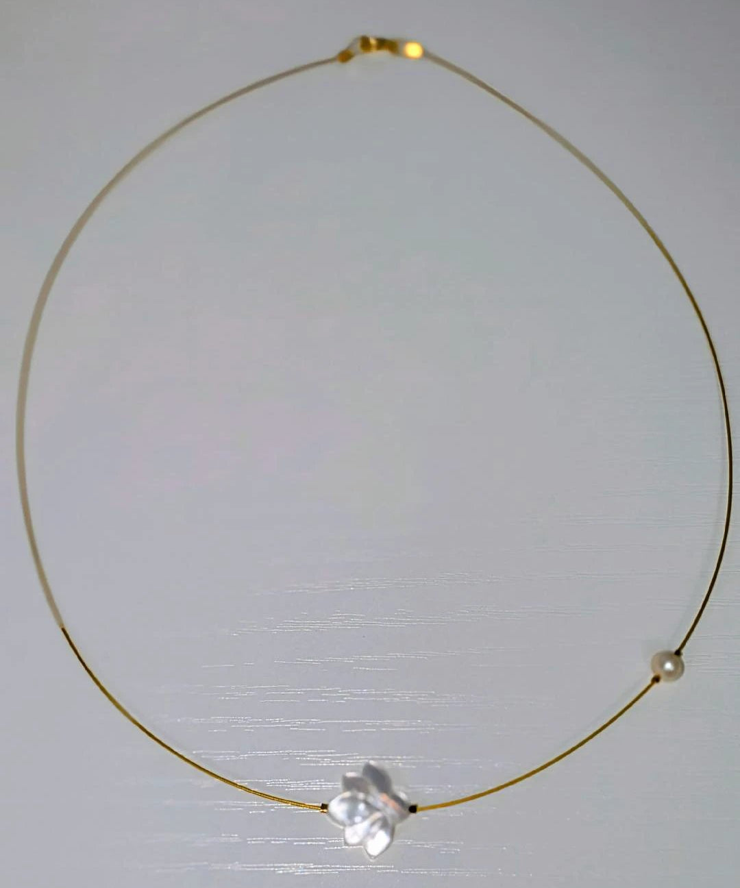 The White Lotus Necklace: delicate gold-tone wire choker with a white lotus flower charm and a pearl bead
