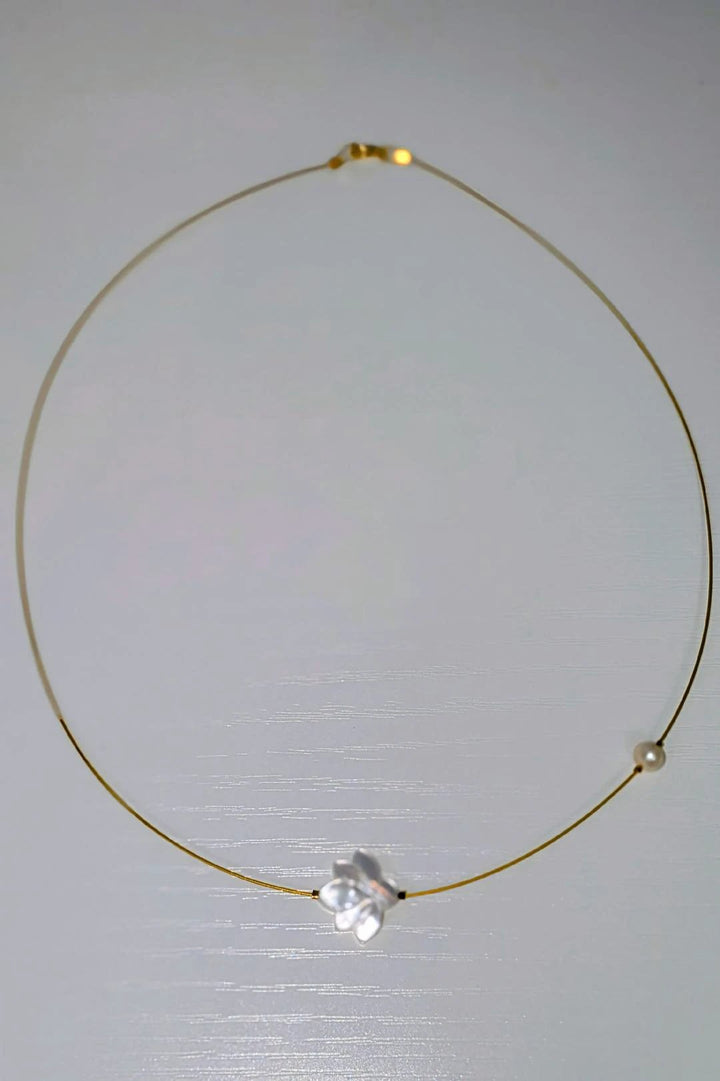 The White Lotus Necklace: delicate gold-tone wire choker with a white lotus flower charm and a pearl bead