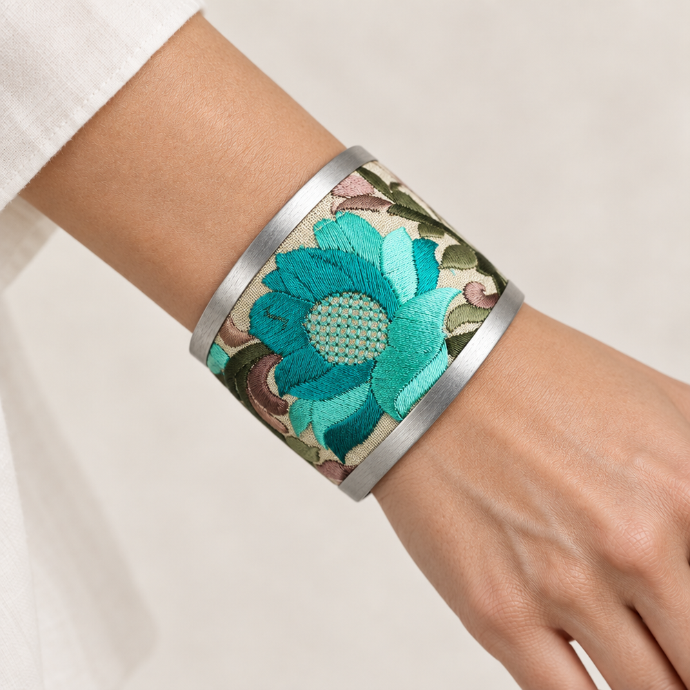 Turquoise floral cuff worn on a wrist with an ivory background